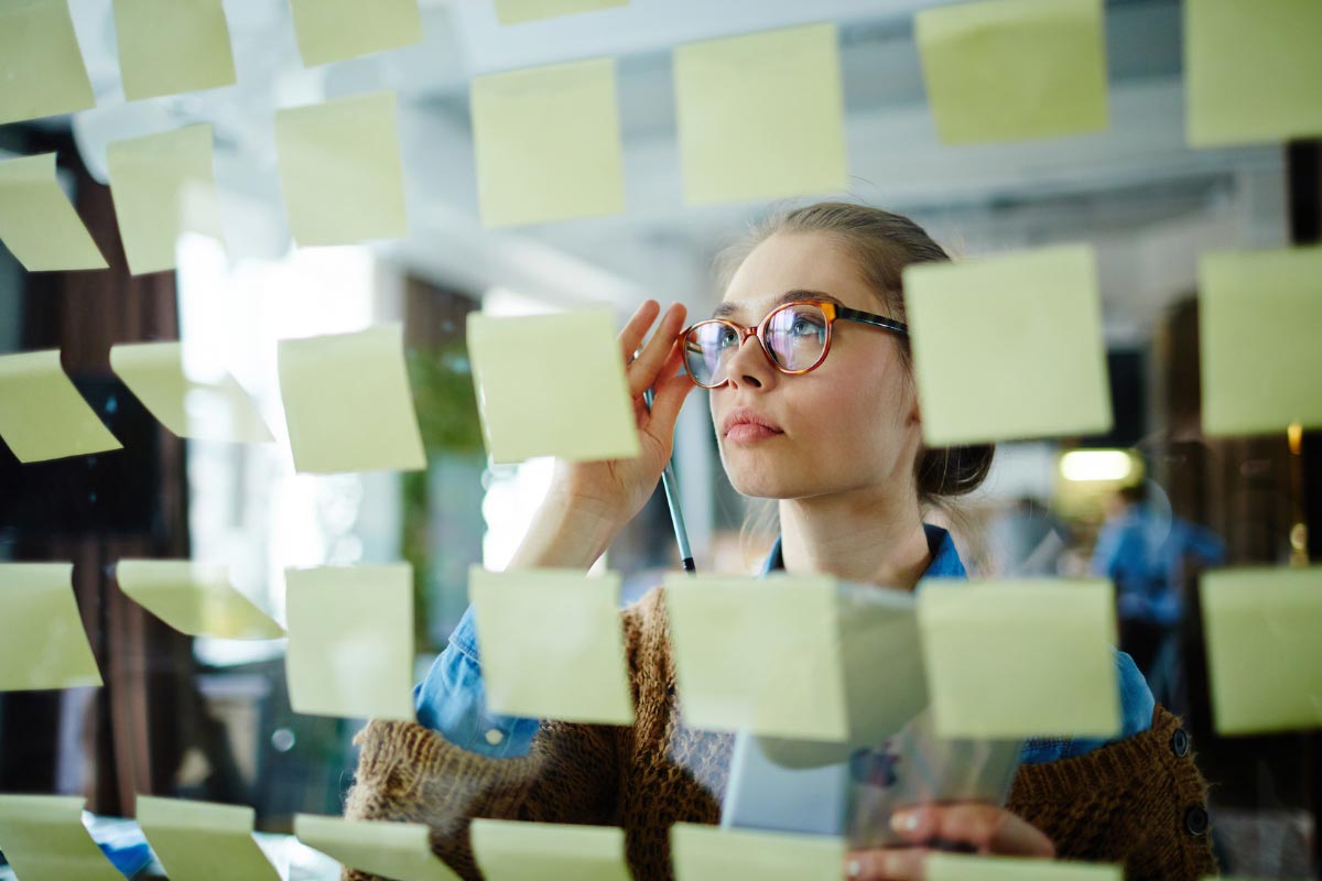 Professional reviewing planning notes to identify gaps in multi-site rollout strategy